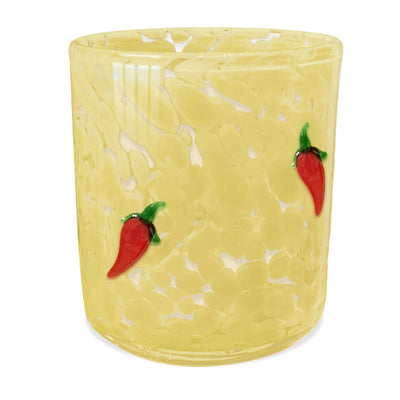 The SOi Companys Golden Paloma 12oz Yellow Pepper Confetti Candle is a translucent yellow glass with a textured, speckled pattern, featuring two small red chili pepper designs with green stems in an elegant cylindrical shape.