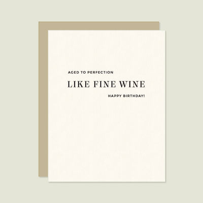The Missive Like Fine Wine Letterpress Birthday Card features the message "Aged to perfection like fine wine. Happy Birthday!" on cream paper with a brown envelope, shown against a light gray background.