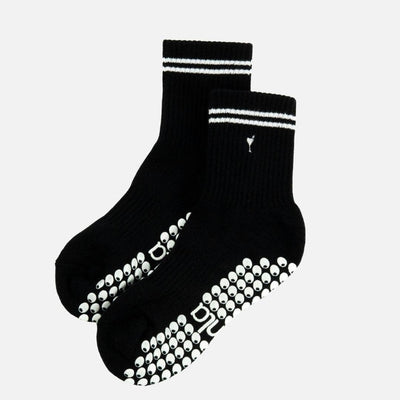 The Almla Active Tiny Martini Pilates and Yoga Non-Slip Grip Crew Sock features a black cotton blend, two white top stripes, side logo, and white grip dots for stability—ideal as Pilates socks.