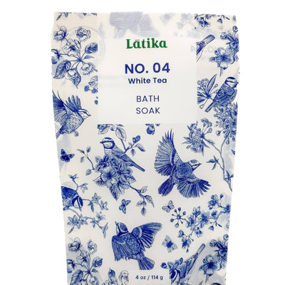 A 4 oz / 114 g package of Latika Beautys White Tea Bath Soak features blue bird and flower illustrations on a white background, providing a soothing coconut milk fragrance.