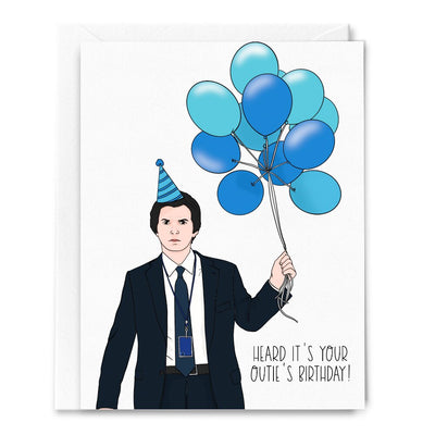 The Outie Birthday Card by Sammy Gorin LLC is an A2 folded card featuring original art of a man in a suit with a striped party hat holding blue balloons. The card reads, Heard it’s your outies birthday!.