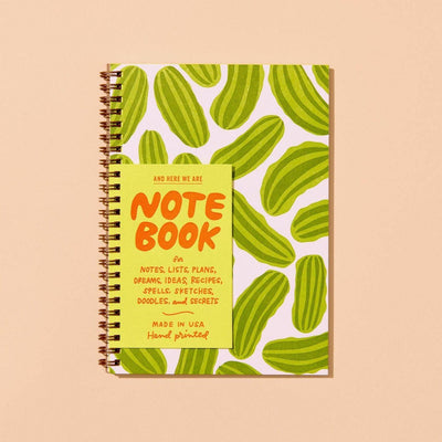 The Pickles A5 Letterpress Spiral Notebook by And Here We Are features a green, oval-leaf patterned cover with a yellow NOTEBOOK label—perfect for jotting down notes, lists, plans, dreams, or recipes with foodie flair.