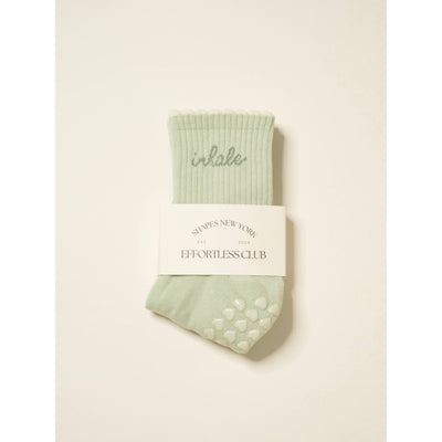 Effortless Club Inhale Exhale Grip Sock in mint green features "inhale" embroidered at the top, ribbed design, cushioned footbed, grip dots on the sole, and comes folded with a white SHAPES NEW YORK EST. 2024 label.