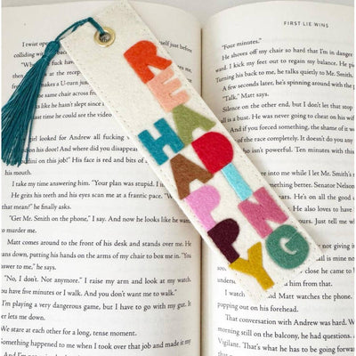 The Milo & Mollie Happy Reading Felt Bookmark features large, colorful cut-out letters and a blue tassel, making it a charming handmade gift for book lovers.