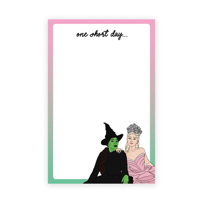 A green-skinned witch in black and a crowned woman in pink gaze at each other on a gradient backdrop. The text one short day... floats above them, all enveloped in a sleek cellophane sleeve labeled OSD Notepad by Sammy Gorin.