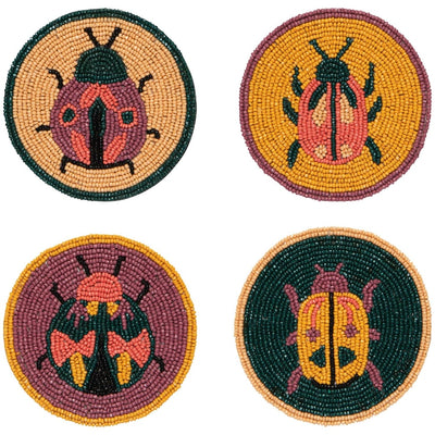 Four round beaded coasters with ladybug designs on a white background