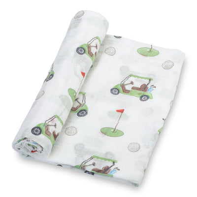 The LollyBanks Golf A Round Baby Swaddle Blanket is a white cotton muslin blanket with green golf carts, golf balls, and putting greens—perfect for keeping your newborn cozy.