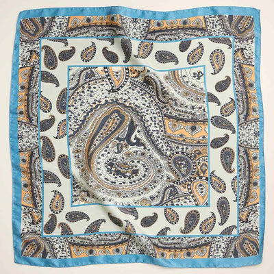 The Sensibling Corp. Vintage Inspired Paisley Pattern Square Silky Satin Scarf features intricate blue, gold, white, and black paisley designs with a light blue border, adding an elegant retro touch to any outfit.