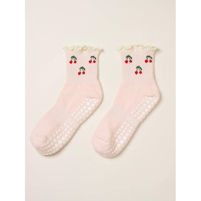 Pair of pink socks with cherry design on a light background