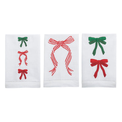 Three white towels with embroidered red and green bows on a white background