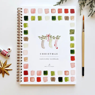 The Emily Lex Studio Christmas Watercolor Workbook is spiral-bound with festive painted swatches, three stocking illustrations, and art supplies on the cover—a perfect watercolor gift for beginners.