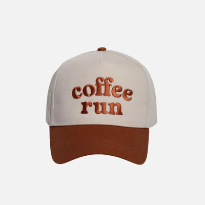 The "coffee run" Embroidered Two Tone Baseball Cap by Judson & Company has a beige crown, brown brim, brown "coffee run" embroidery, and an adjustable snap back. Made from 100% cotton for comfort and style.