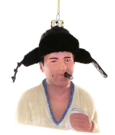 The Cousin Eddy Ornament by Cody Foster is a 4" glass Christmas tree decoration shaped like a person with a black furry hat, cream shirt with blue trim, holding a cup, with a cigar and slight smile—a charming holiday accent.