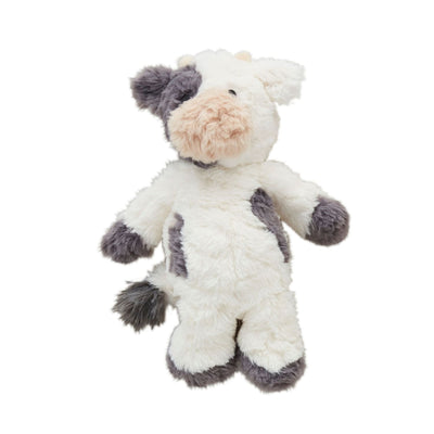 The Mud Pie Cow Plush stands upright against a plain white background, featuring a soft, fluffy texture with plush faux fur in white and dark gray patches. It has large ears and a tufted tail.