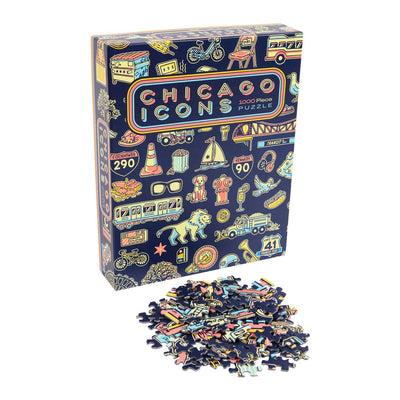The Transit Tees Chicago Icons 1000 Piece Puzzle box displays vibrant city landmark illustrations, with spread-out pieces in front matching the colorful designs and symbols on the packaging.