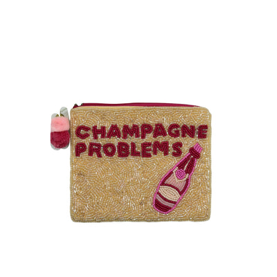 The Champagne Problems Beaded Pouch by Pizzazz, Inc. is a small beige zippered pouch (5.5 x 4.5 in), handmade in India with beaded "CHAMPAGNE PROBLEMS" text, a pink champagne bottle, and a pink and white beaded zipper charm.
