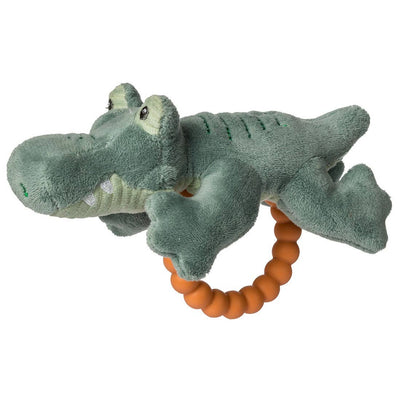 The Mary Meyer Afrique Alligator Teether Rattle is a soft green plush with embroidered eyes and snout, attached to an orange beaded ring. It features a rattle inside and serves as a baby-safe silicone teething toy or playful plush.