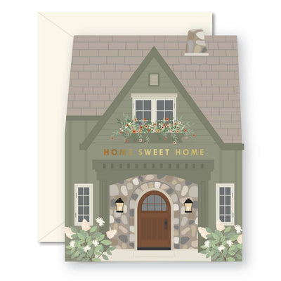 The Green Home Sweet Home Greeting Card by Ginger P. Designs features a die-cut green house with Home Sweet Home above a brown front door, stone accents, lanterns, flowers, gold foil details, and includes an envelope—ideal for new homeowners.