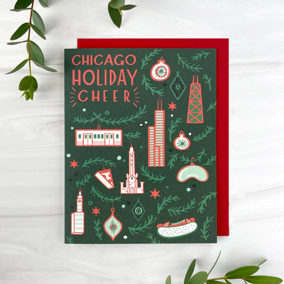 The Chicago Ornaments Card (Box Set of 6) by Paper Parasol Press features "Chicago Holiday Cheer" in bold on a dark green A2 card, decorated with city icons, ornaments, and greenery. Includes red envelopes—perfect blank holiday cards for greetings.