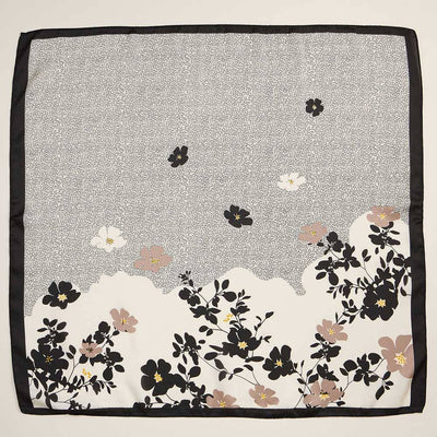 The Minimal Floral Border Printed Square Silky Satin Scarf by Sensibling Corp. features a floral design with black and beige flowers with yellow accents at the border, and dotted patterns with blossoms on a white background.