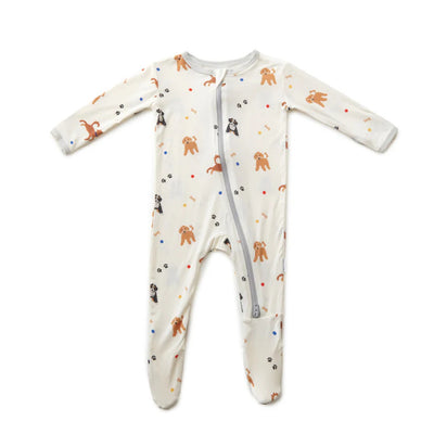 The Bamboo Little Dogs Zippered Footie is a white, eco-friendly bamboo baby onesie with long sleeves and legs, a front zipper, and a playful brown and black dog print with colorful dots.