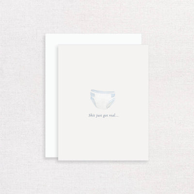 The Shit Just Got Real Baby Diaper Greeting Card by Korynne and Company features a watercolor diaper and the phrase Shit just got real... beneath, printed on textured felt paper with a clean white background.