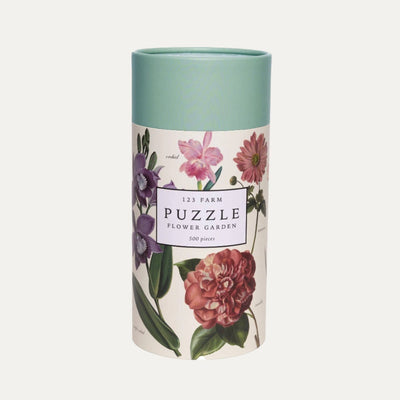 Packaged in a cylindrical tube with a teal lid, 123 Farm’s Flower Garden Puzzle features vintage-style floral illustrations and contains 500 pieces inspired by an organic farm.