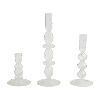 Set against a white backdrop, Mud Pies Glass Dot Candlesticks, with their varying heights, showcase sculpted bubble-like designs. Their round bases and slender textured stems bring an artistic flair to these elegant dimensional glass pieces.