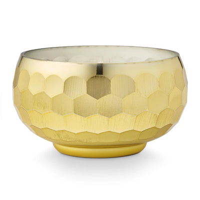 The Glittering Garland Disco Bowl Candle by Illume Candles features a round, gold-toned honeycomb-textured vessel with a smooth interior, ideal for showcasing its plant-based wax on a simple white background.