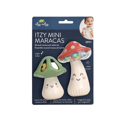 The Itzy Ritzy Itzy Mini Maracas packaging shows two mushroom-shaped rattles for rhythm development: one green/yellow, the other white/red with colorful beads. A smiling baby is in the top right corner. Suitable for ages 0 months and up.