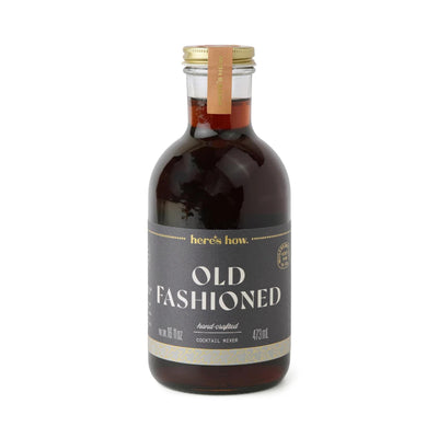 Bottle of 'Old Fashioned' cocktail mixer with a gold cap on a white background