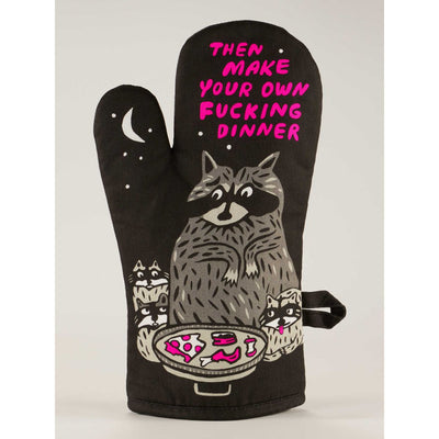 The Blue Q Make Your Own Dinner Oven Mitt is black and shows a cartoon raccoon chef with two smaller raccoons, a food pan, crescent moon, and bold pink text: Then make your own fucking dinner.