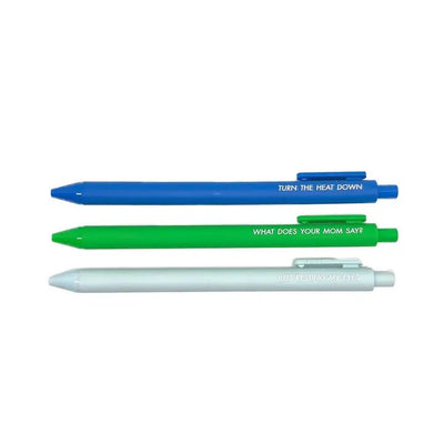 The Pens for Dads Who Need a Break by Tiny Hooray feature three horizontal jotter pens: a blue pen with TURN THE HEAT DOWN, a green pen with WHAT DOES YOUR MOM SAY?, and a white pen with JUST RESTING MY EYES, each inscribed in sleek black gel ink.