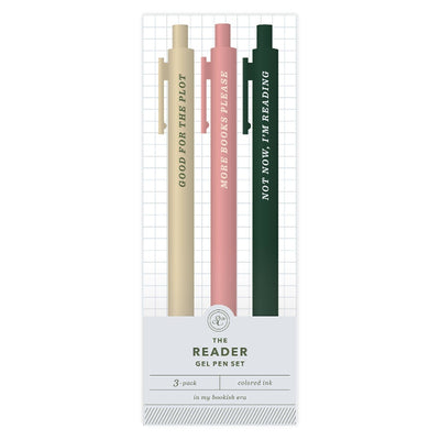 The Reader Pen Set by Studio Calico features three gel pens in cream, pink, and dark green with book-themed phrases and colored ink—an ideal gift or stationery set for any book lover. 3-pack.