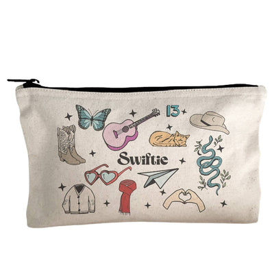 The Swiftie Collage Canvas Zipper Pouch by Moonlight Makers features cowboy boots, a butterfly, guitar, stars, and “Swiftie” at the center—a stylish and eco-friendly makeup bag for fans.