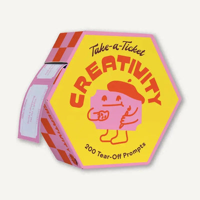 A hexagonal yellow and pink box, Take-a-Ticket: Creativity by Chronicle Books, features a cartoon with pencil and paper. It holds 200 tear-off prompts to spark creativity, with tickets visible on the side.