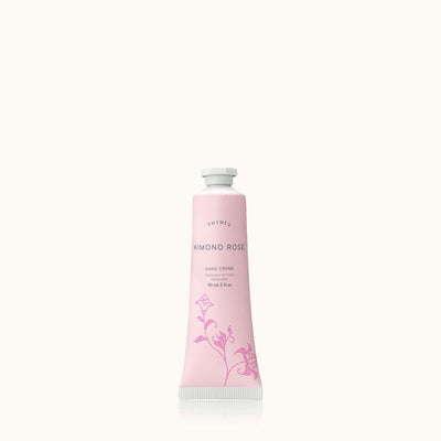 A tube of Thymes Kimono Rose Petite Hand Creme sits against a plain backdrop. The elegant pink tube features floral designs and a white cap. Infused with shea butter, this 90 ml (3 fl oz) hand creme delivers luxurious skin nourishment.