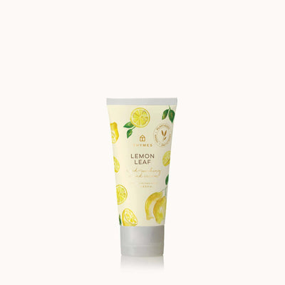 Thymes Lemon Leaf Hard-Working Hand Cream, with Shea Butter and Pro-Vitamin B5, features water lily, bergamot, and lemon designs on a light yellow background against a clean white backdrop.