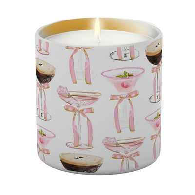 The Very Merry Candle by Annapolis Candle is a white soy wax candle in a glass jar, featuring cocktail illustrations with pink bows and garnishes—a festive Rebecca Meixner design for any space.