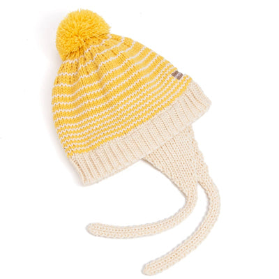 The Peppercorn Kids Earflap Winter Hat-Woolly Stripe is a yellow and white striped knit beanie with a big yellow pom-pom, cream ear flaps, and braided ties—perfect for keeping toddlers cozy.