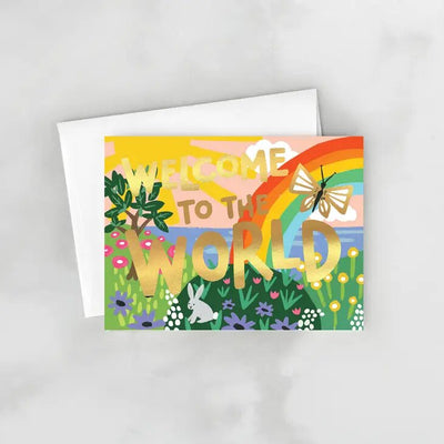 The Idlewild Co. Welcome to the World Greeting Card features a vibrant hand-painted Welcome to the World message with rainbows, butterflies, and a sunny sky—a perfect gift for new parents. It comes with a matching envelope.